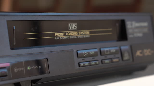 VHS Videotape and Video Player, Loading Tape and Pressing Play Button, Close Up
