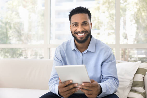 istock Happy handsome young Black man holding tablet, looking at camera 2066530707