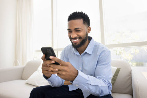 istock Happy young Black man typing on smartphone with toothy smile 2066537581