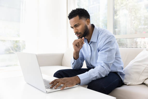 istock Focused young African freelancer man typing on laptop at home 2066555833