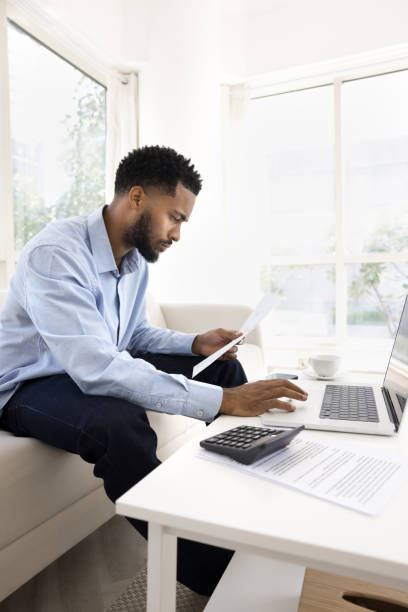 istock Focuses young African freelancer man working on paper financial reports 2066558914