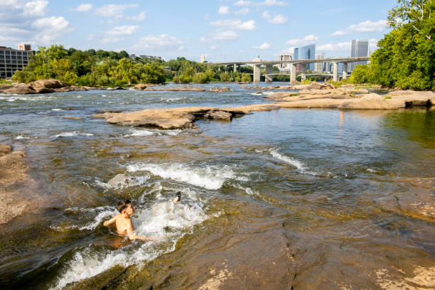istock Teenage boy swimming in river rapids 2066576875