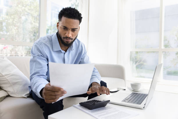 istock Serious young African American man calculating expenses 2066584725