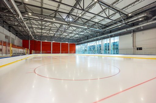 Sleek Ice Rink in a Modern Facility Featuring Expansive Glass Walls and Metal Framework
