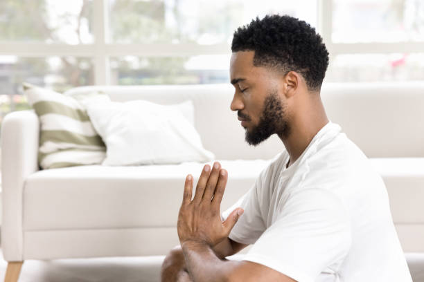 istock Focused calm African American guy meditating at home 2066602588