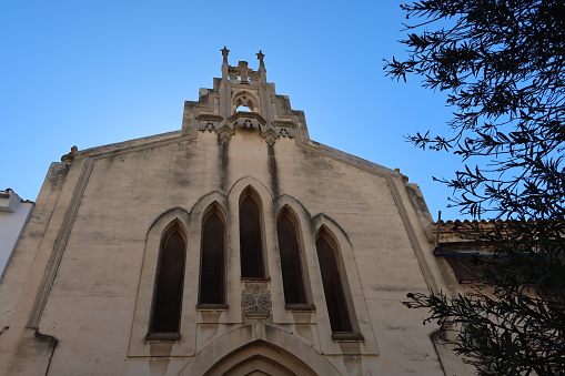 Villena, Alicante, Spain, March 5, 2024: Windows and bells on the facade of a church in the Plaza de las Malvas in Villena, Alicante, Spain