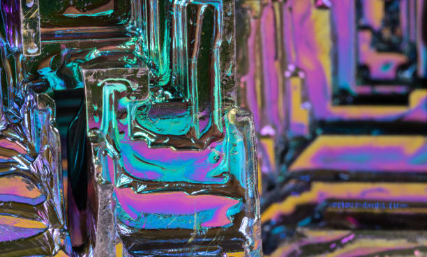 Closeup of hopper crystal of bismuth chemical element - Bi in colored iridescent background stock photo