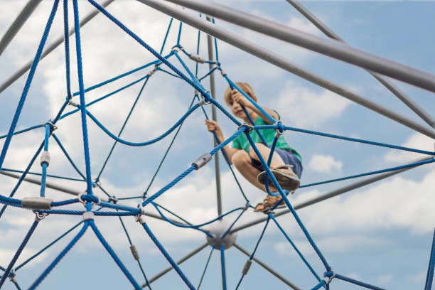 istock Young boy on climbing rope in playground 2066616720
