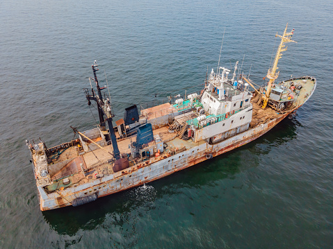 Old rusty ship at sea. Obsolescence of ships concept. Old ships pollute the environment.