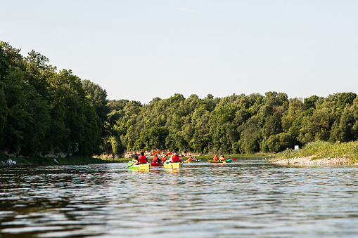 Group of friends  travel by kayaks.  Peacefull nature scene of calm river. Water tourism concept