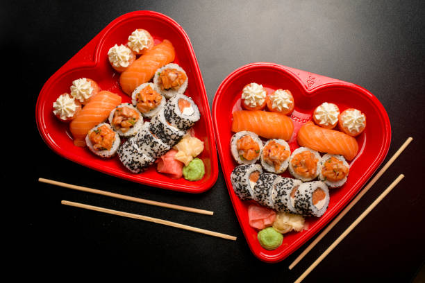 istock Top view of two heart-shaped sushi boxes with chopsticks 2066649444