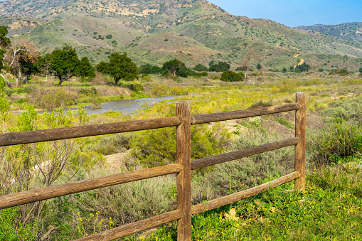 A wooden corral fence with a landscape of Irvine Regional Park in Orange County, California