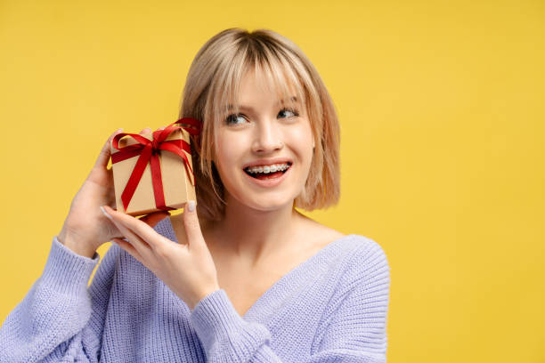 istock Satisfied young female holding wrapped gift box, receiving present, looking smiling at camera 2066670767