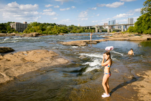istock Little girl playing with water on the riverside 2066688103
