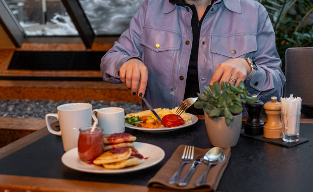 istock Woman Enjoying a Full Breakfast Plate at a Cozy Hotel Setting 2066689313