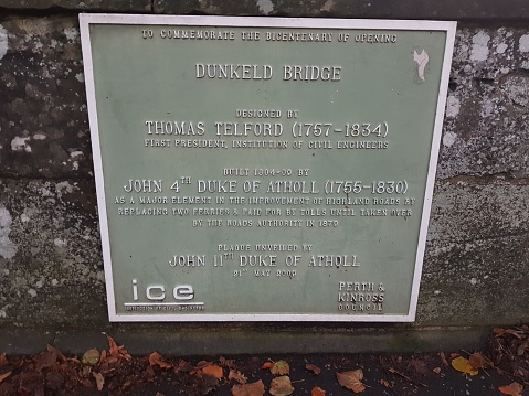 A commemorative plaque about the opening and history of Dunkeld Bridge in Dunkeld, Perth and Kinross, Scotland, England UK