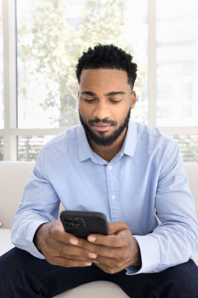 istock Serious young handsome Black man typing on mobile phone 2066708241