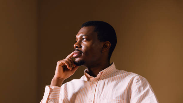 Contemplative African American Man Looking Out Window in Thought
