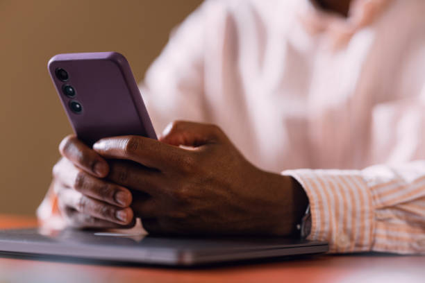 istock Close-up of Man with Smartphone at Work Desk Communicating over Text 2066722652