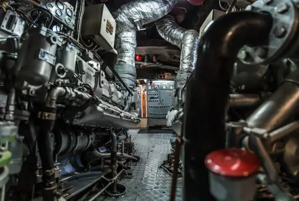 Complex interior of a ship's engine room with machinery and metal piping