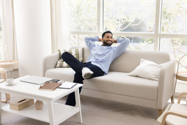 istock Cheerful young black freelance employee man stretching body on couch 2066724823