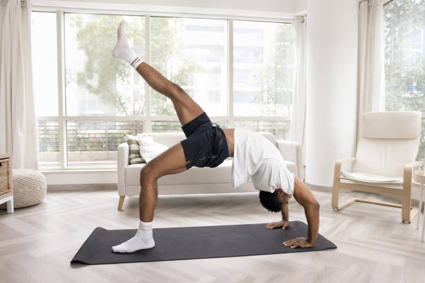 jeune homme africain athlétique fort faisant un stand de pont - yoga men bridge bending over backwards photos et images de collection