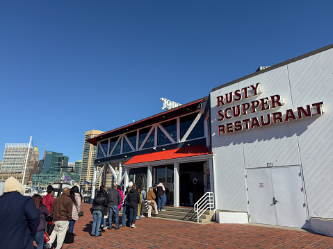 Baltimore, USA - February 18, 2024. People lining up for brunch outside Rusty Scupper Restaurant at Baltimore Inner Harbor, Maryland, USA