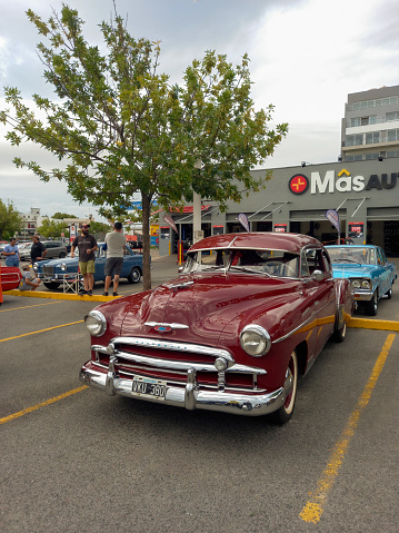 Buenos Aires, Argentina - Feb 25, 2024: Old red shiny 1949 Chevrolet Styleline two door sedan at a classic car show in a parking lot.