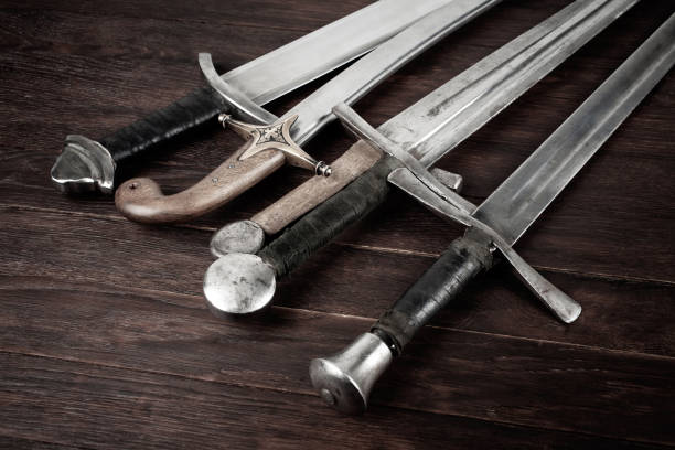 istock Swords and sabre on wooden background. 2066868515