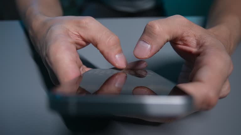 Closeup top view of unrecognizable young adult man using cellphone for writing send message. Concept mobile tech 5g, people sharing and reading sms display.