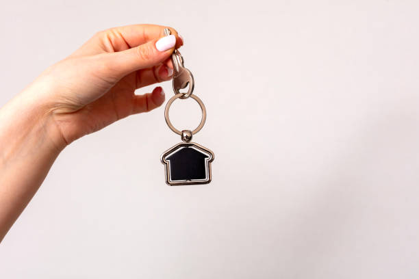 close-up of a woman's hands holding the keys to a new house, - new home construction 뉴스 사진 이미지