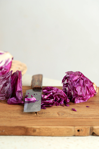Fresh Cut Sliced Raw Purple Red Cabbage on Wooden Chopping Board with Knife, Copy Space for Text