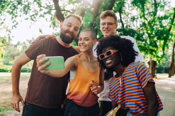 istock A group of multicultural friends taking selfies at the park. 2066880757