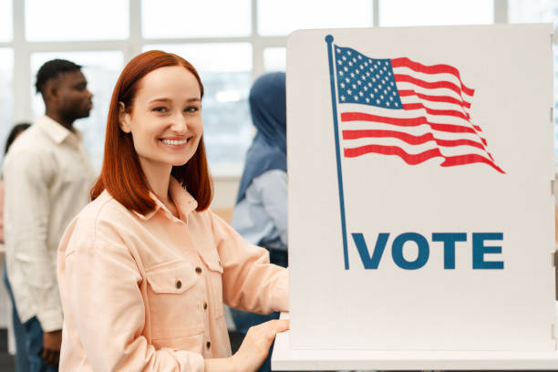 Smiling red haired woman vote at polling station . Democracy, United States election day 2024