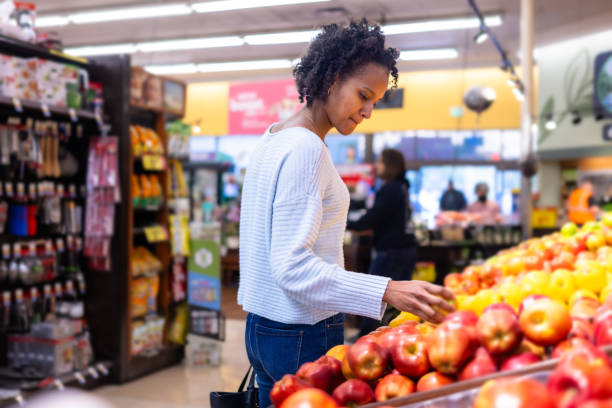 istock Young black woman browsing produce in grocery store 2066901975