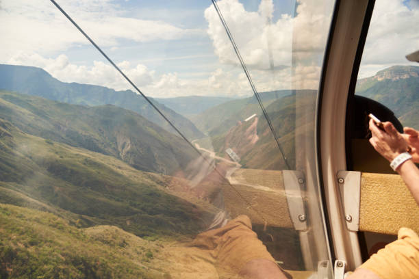 Unrecognizable person inside a cable car cabin in the Chicamocha Canyon, in Santander, Colombia.