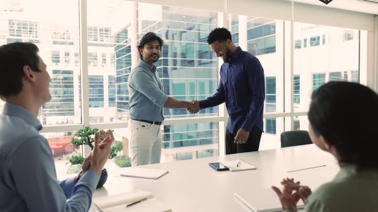 Indian male boss congratulate with promotion African employee