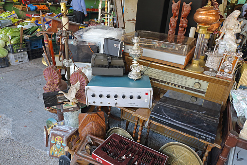 Large mix of second and and vintage  stacked household objects at Vintage market stall opposite to Chatuchak Weekend market in Bangkok. Small vintage and second hand market outside of a vintage market shopping mall.