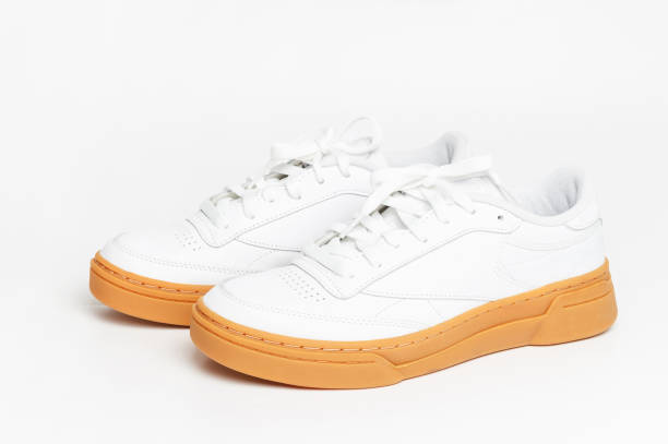 istock White sneaker with brown sole on white background close-up, side view. 2066998243