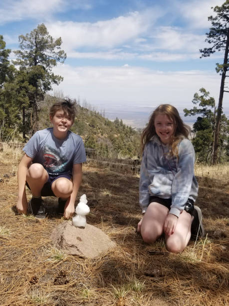 istock Girl and boy showing off their tiny snowman 2066999314