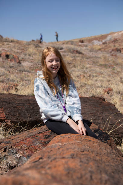 istock Girl smiling while sitting on a petrified log 2066999861