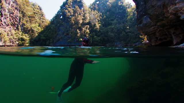 Freediver swims underwater in the lake