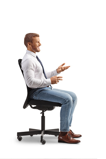 Profile shot of an office worker sitting in chair and talking isolated on white background
