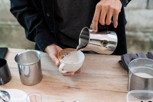 istock Man using pouring coffee to make a hot latte with equipment tool brewing, coffee table. Preparing drink menu 2067039341