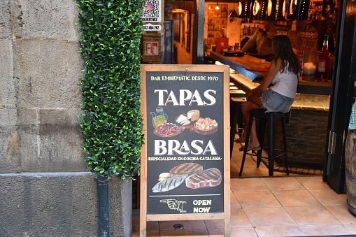 Barcelona, Catalonia- Spain- 10-17-2023: Signage in front of a typical tapas bar in Barcelona's gothic quarter. (selective focus)