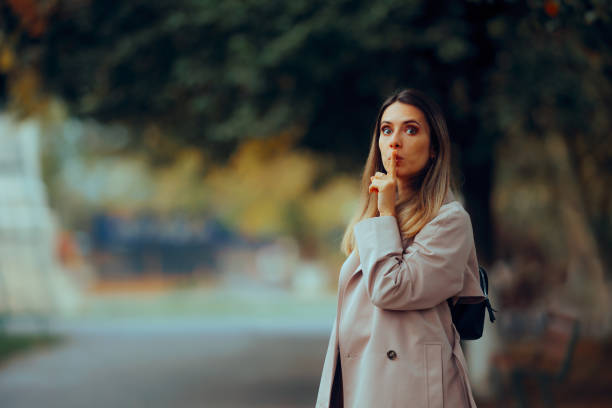 Woman Making Sush Gesture with Finger on the Lips