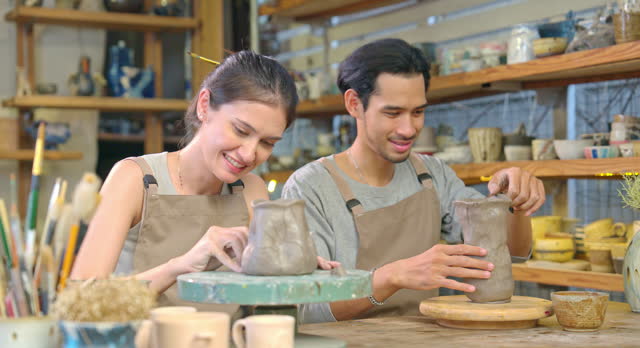 Couple Sharing Laughter During Pottery Workshop