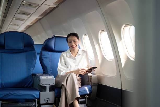 istock Traveling and technology. Flying at first class. Young business woman passenger using smartphone while sitting in airplane flight 2067184788