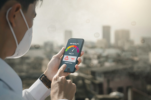 air pollution quality of dust PM 2.5 is toxic and dangerous to health. 
People use technology smart phone check air quality smog from PM2.5 dust, warning dangerous unhealthy air pollution dust smoke