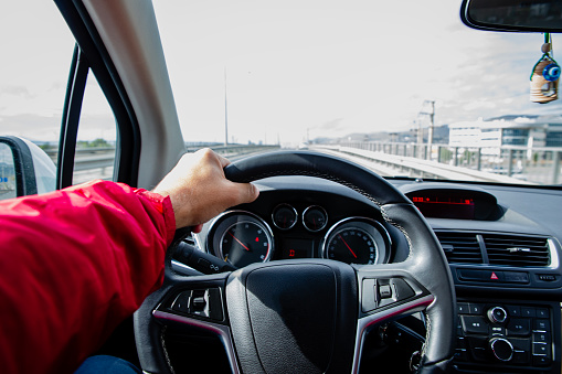 Hand Holding a Steering Wheel Driving